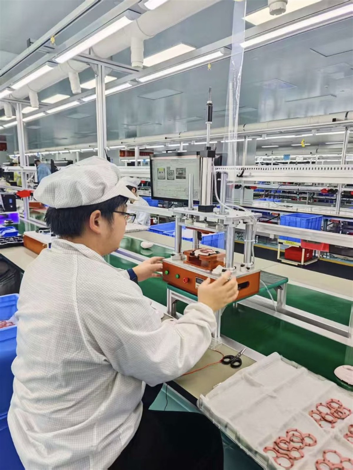 操作员将滚筒电机组件装入测试治具进行功能检查